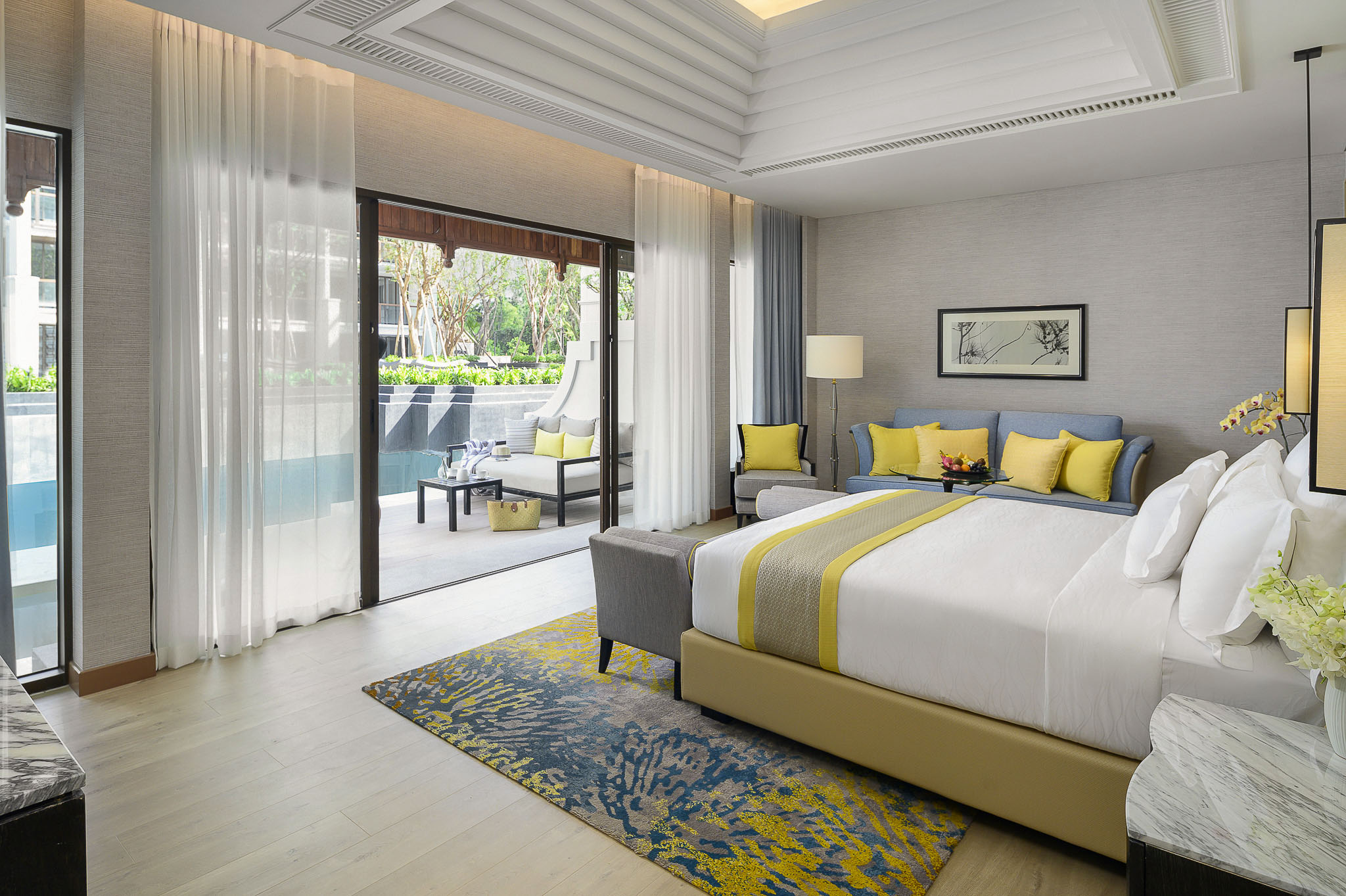 Twin hotel room with pale wood interiors and a pool view